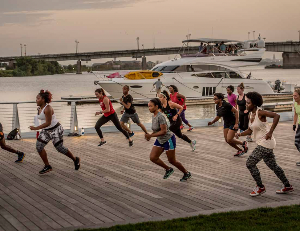 Diverse runners in active wear on the waterfront at dusk